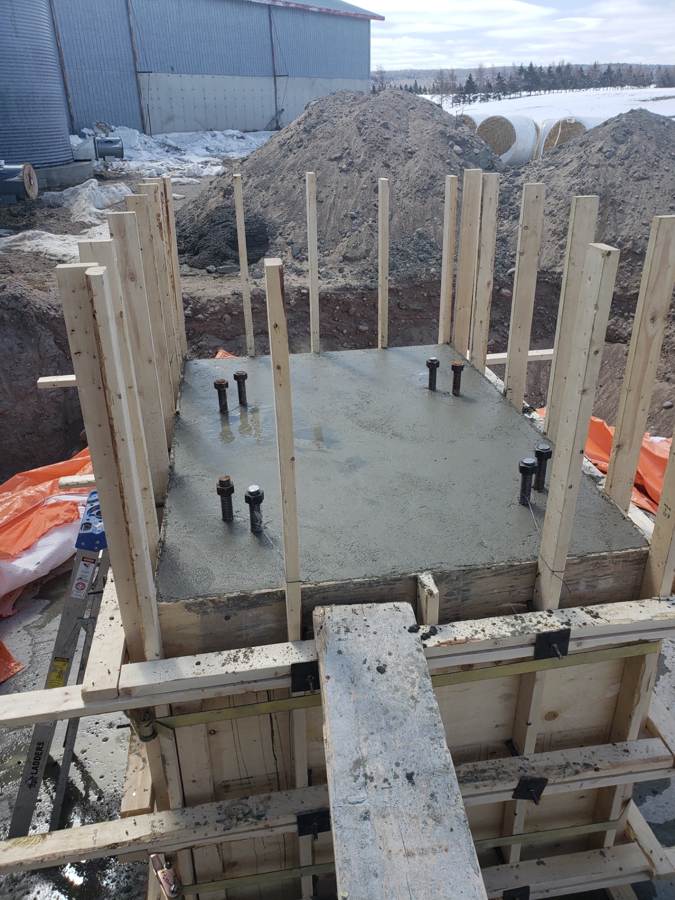 Base de béton coffrée avec boulons d'ancrage